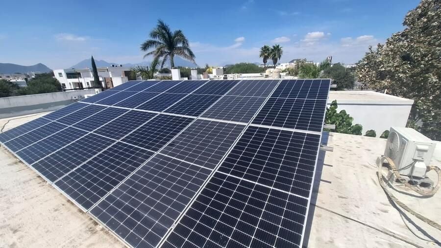 Paneles solares en techo de casa con vista a la ciudad